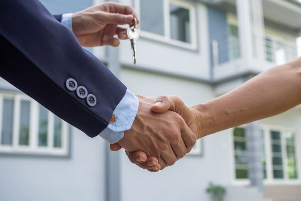 agent-sells-house-shake-hand-with-buyer-send-house-key-buyer(1)(1)